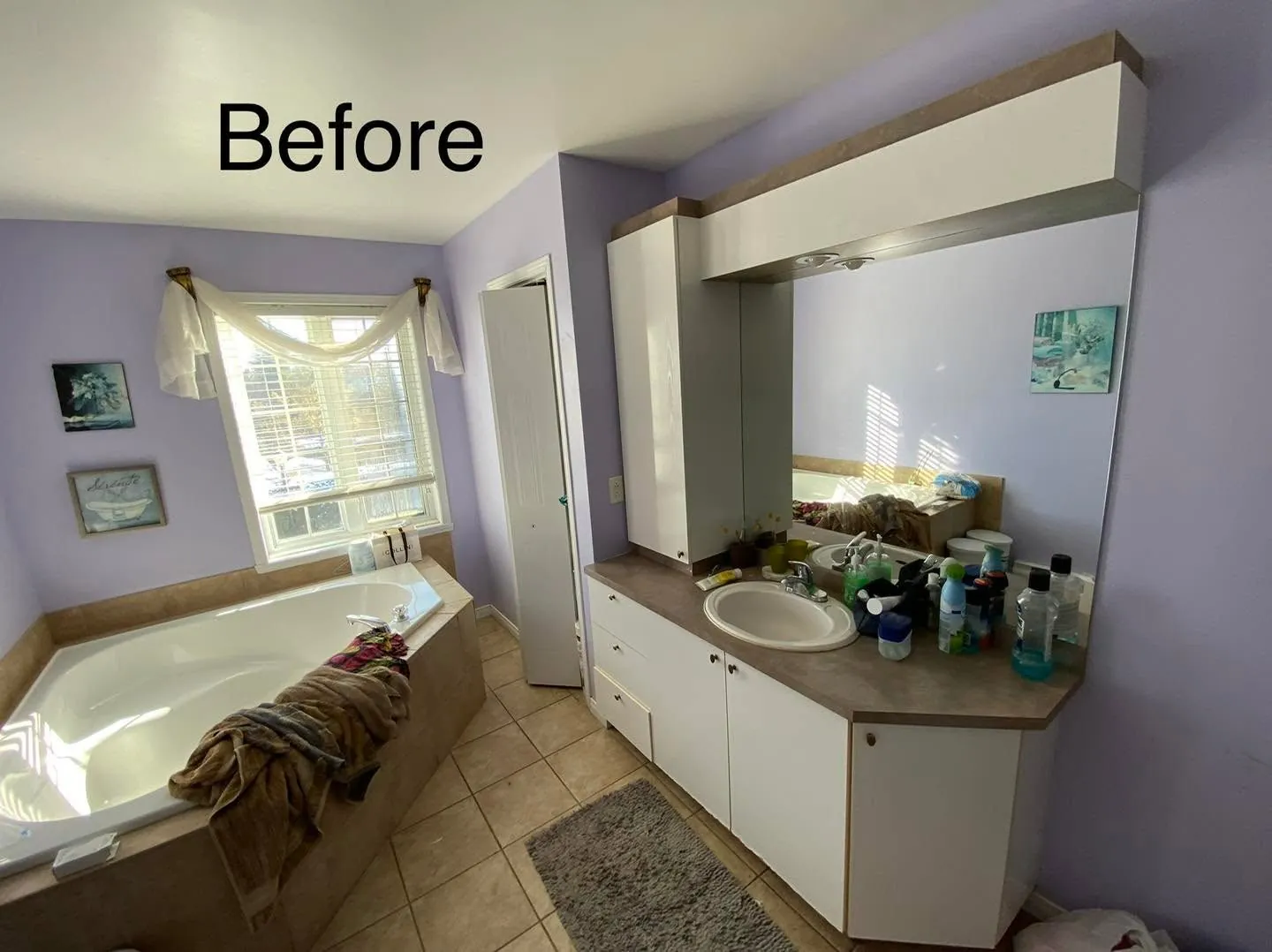 Bathroom with lavender walls, a corner tub and a laminate vanity